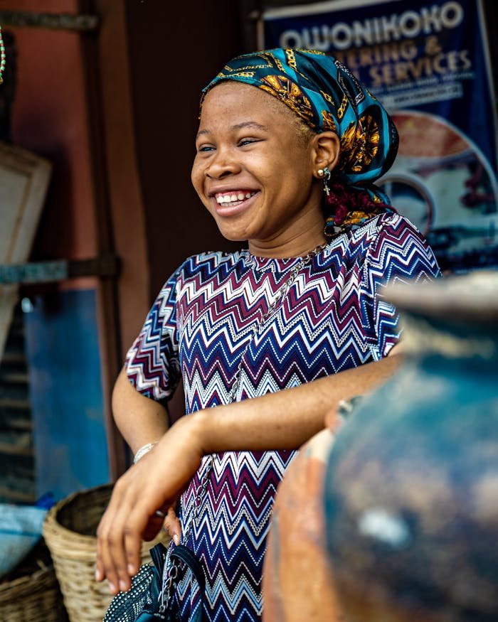 A cheerful African woman standing in an Osun market, Nigeria, exuding happiness and warmth.